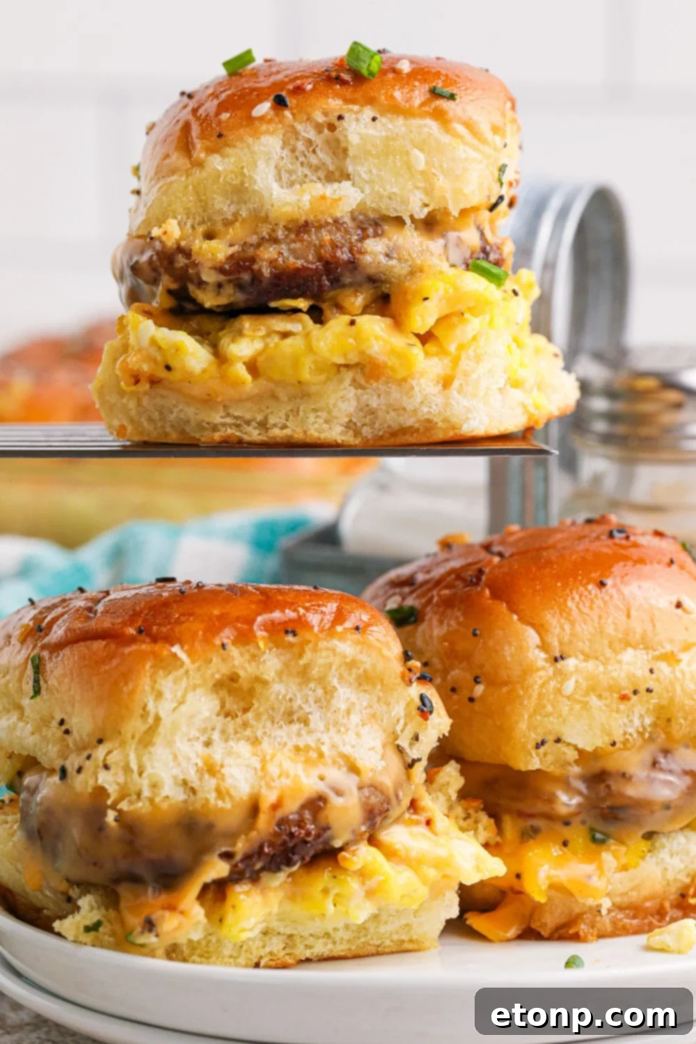 Breakfast Sliders on a plate with one on a spatula above plate 