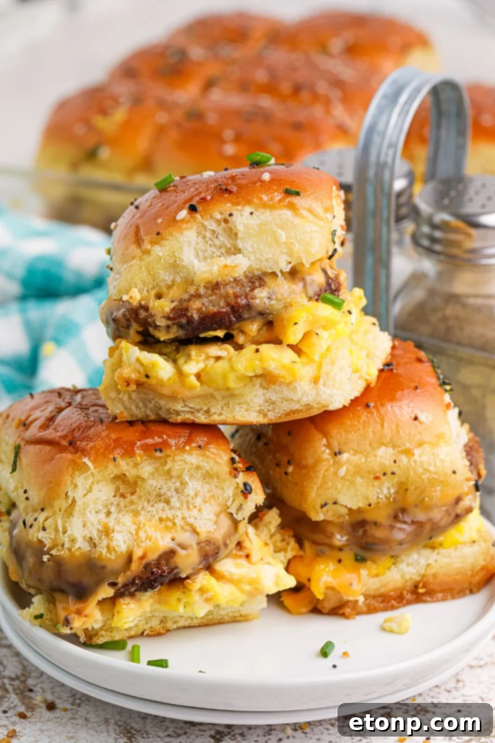Breakfast Sliders on a plate with a close up so you can see the fillin in each sandwich