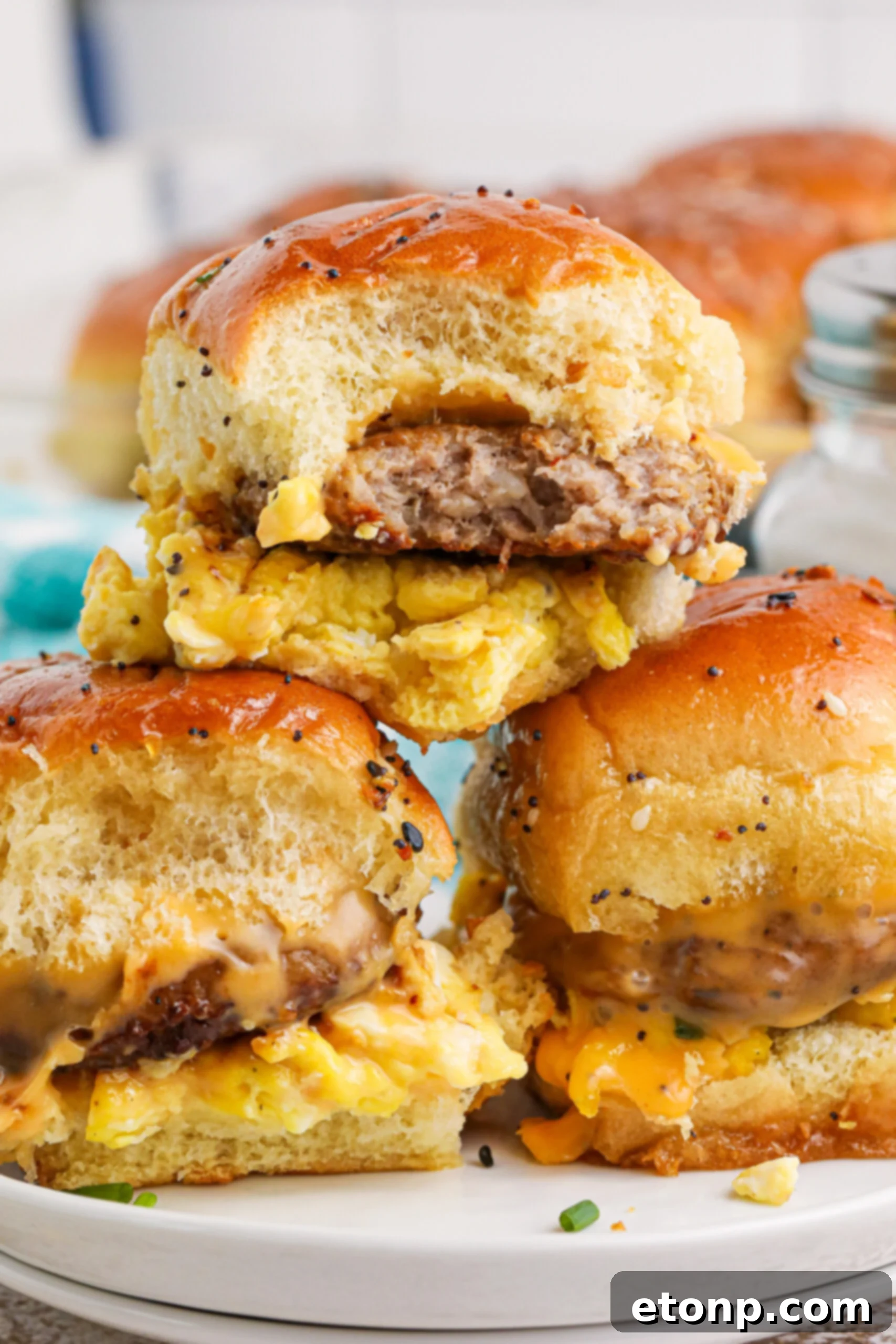 Breakfast Sliders with Sausage cheese and eggs on a white plate stacked