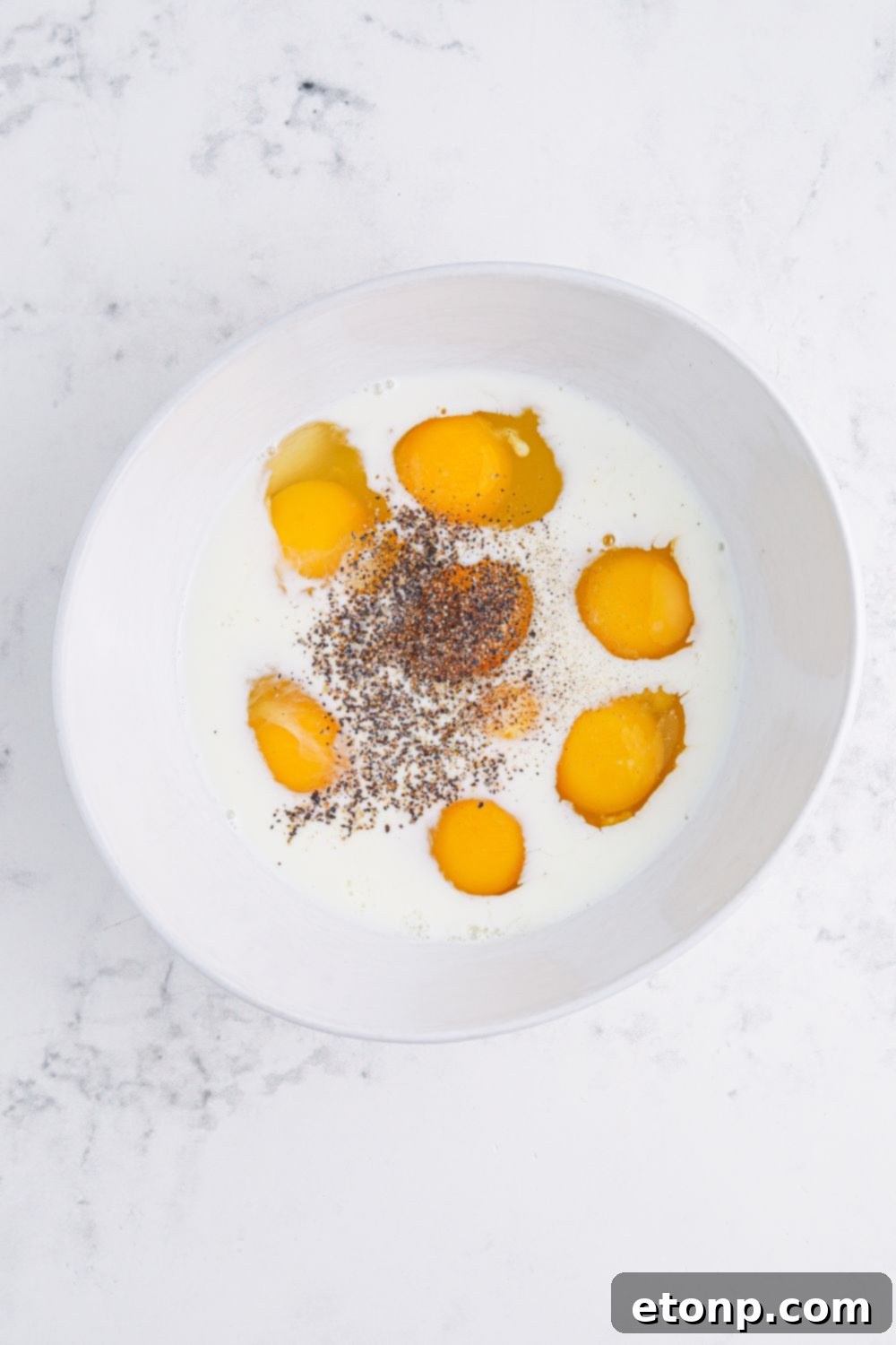 mixing up eggs with milk and seasonings for Breakfast Sliders