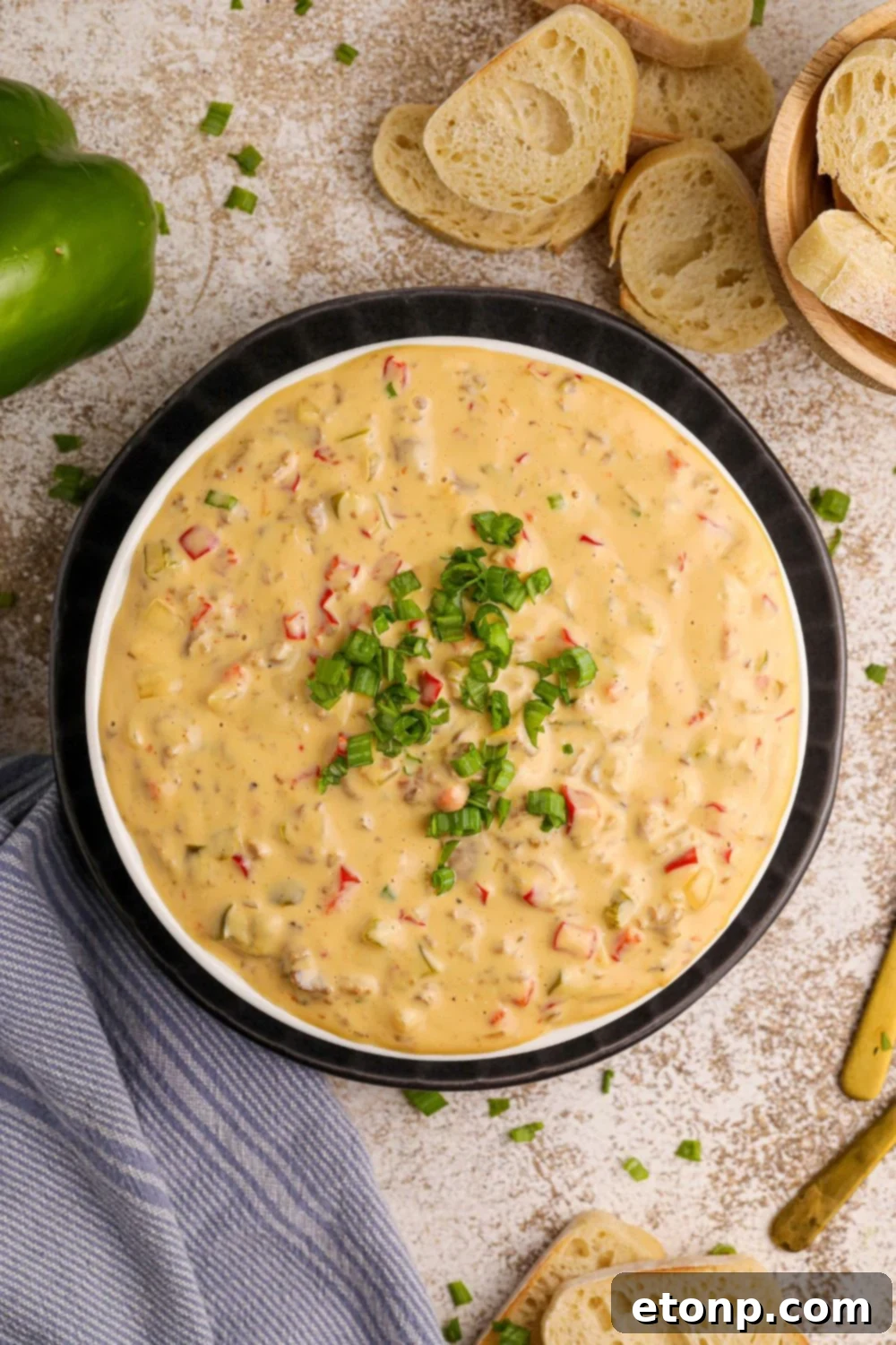 Crock Pot Philly Cheesesteak Dip in a bowl with some green garnish on top 