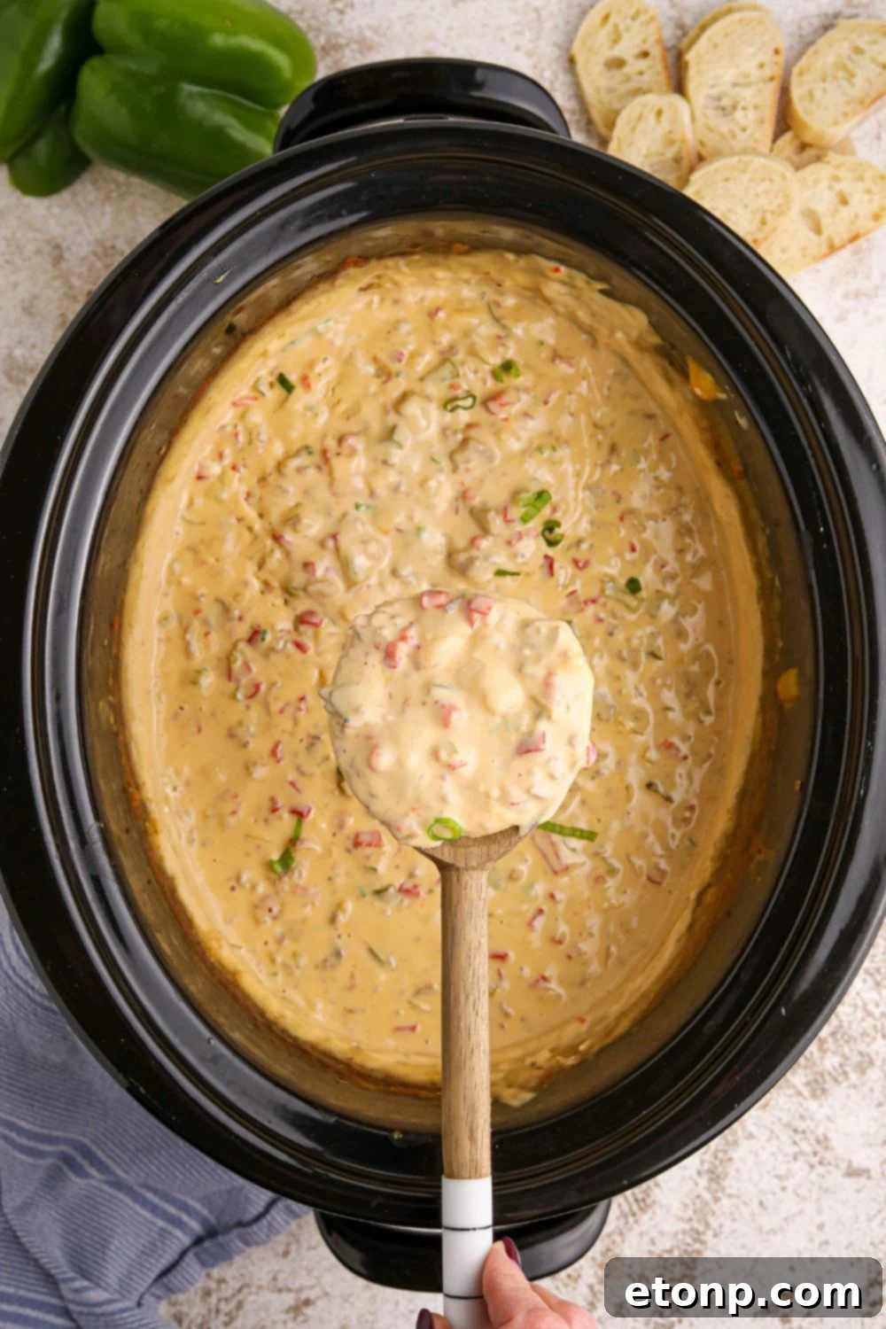 Crock Pot Philly Cheesesteak Dip in a slow cooker with a spoon full of dip over the crockpot 