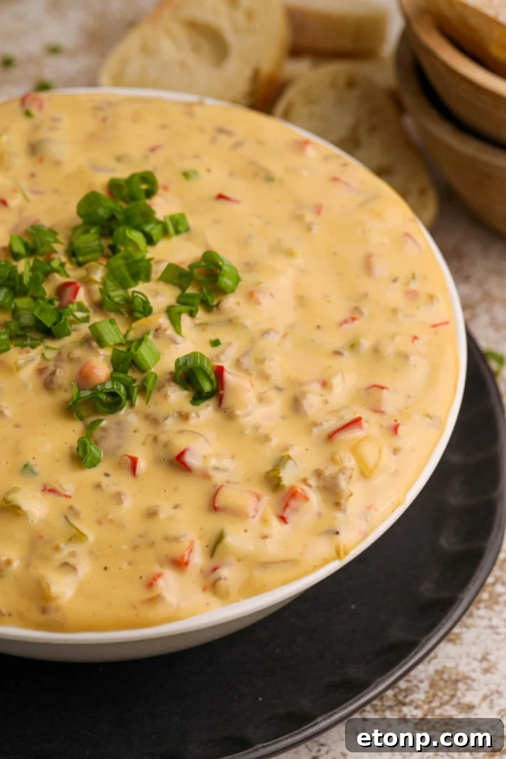 Crock Pot Philly Cheesesteak Dip in a white bowl on table with garnish on top 