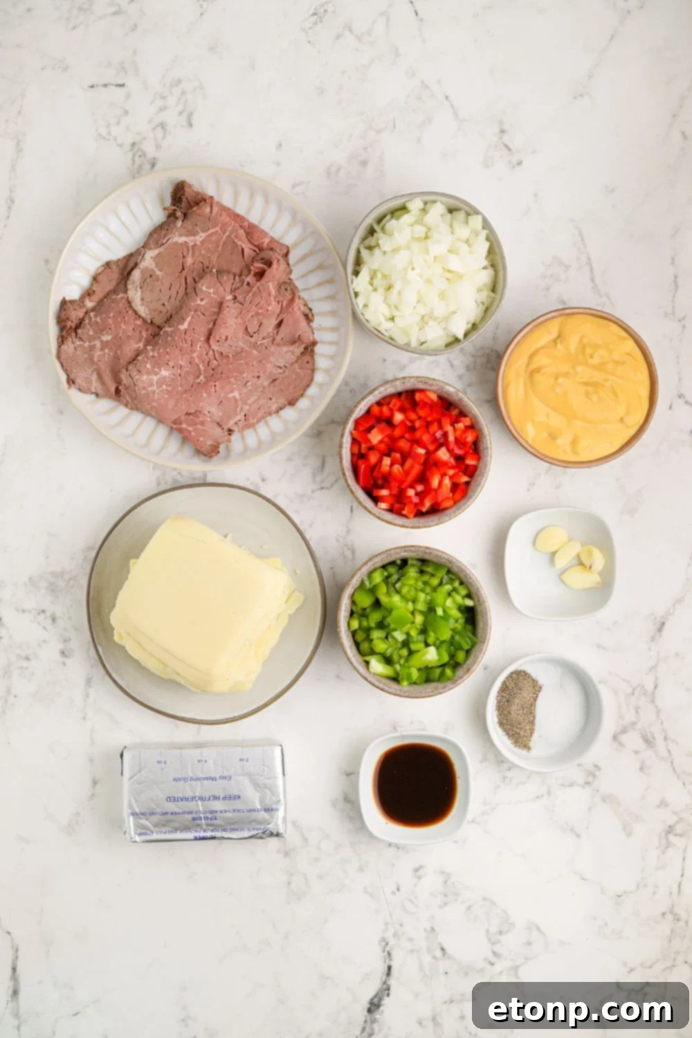 Crock Pot Philly Cheesesteak Dip ingredients on the table in small glass bowls to show all items used 