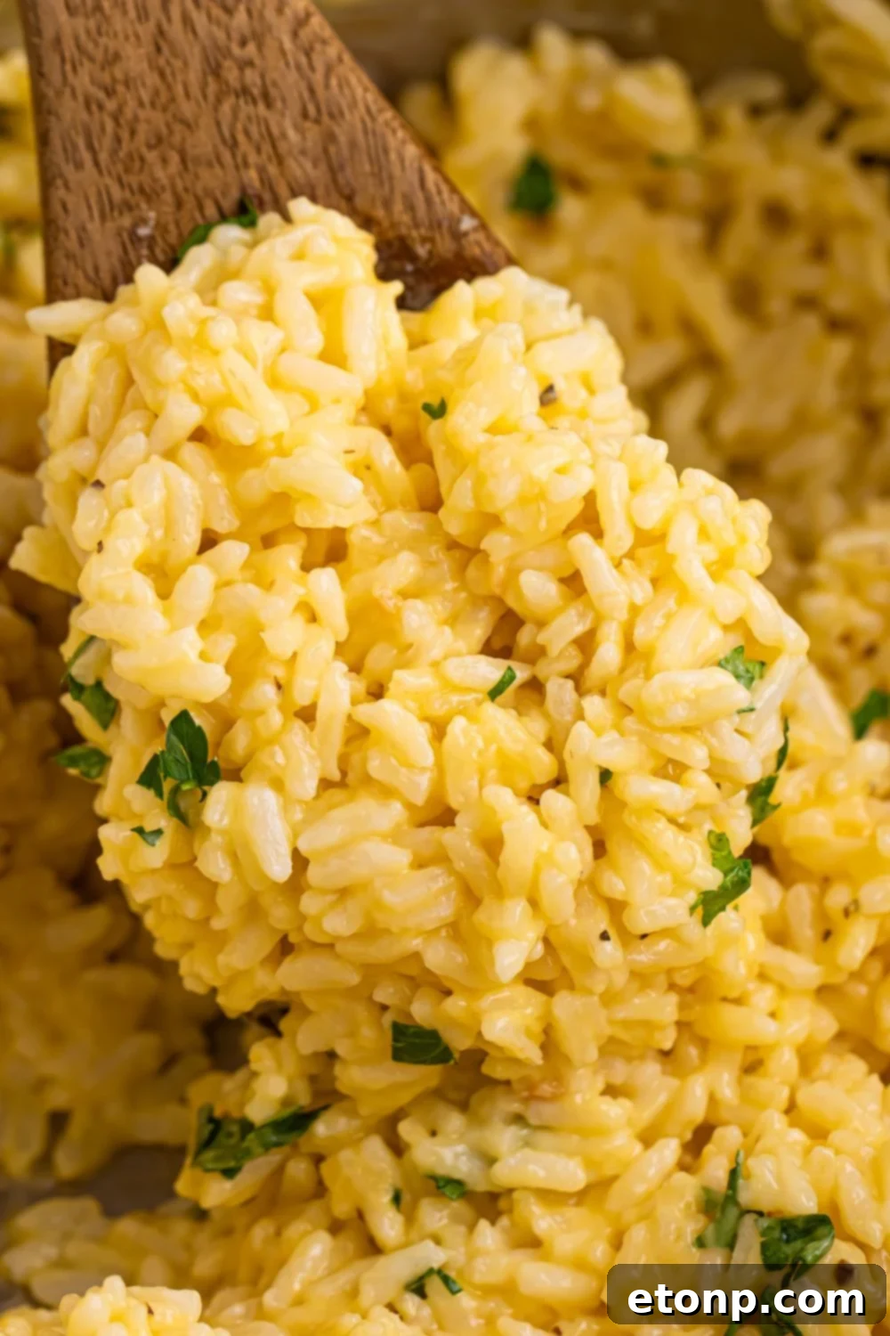 Souper Rice being scooped out of pan with a wooden spatula 