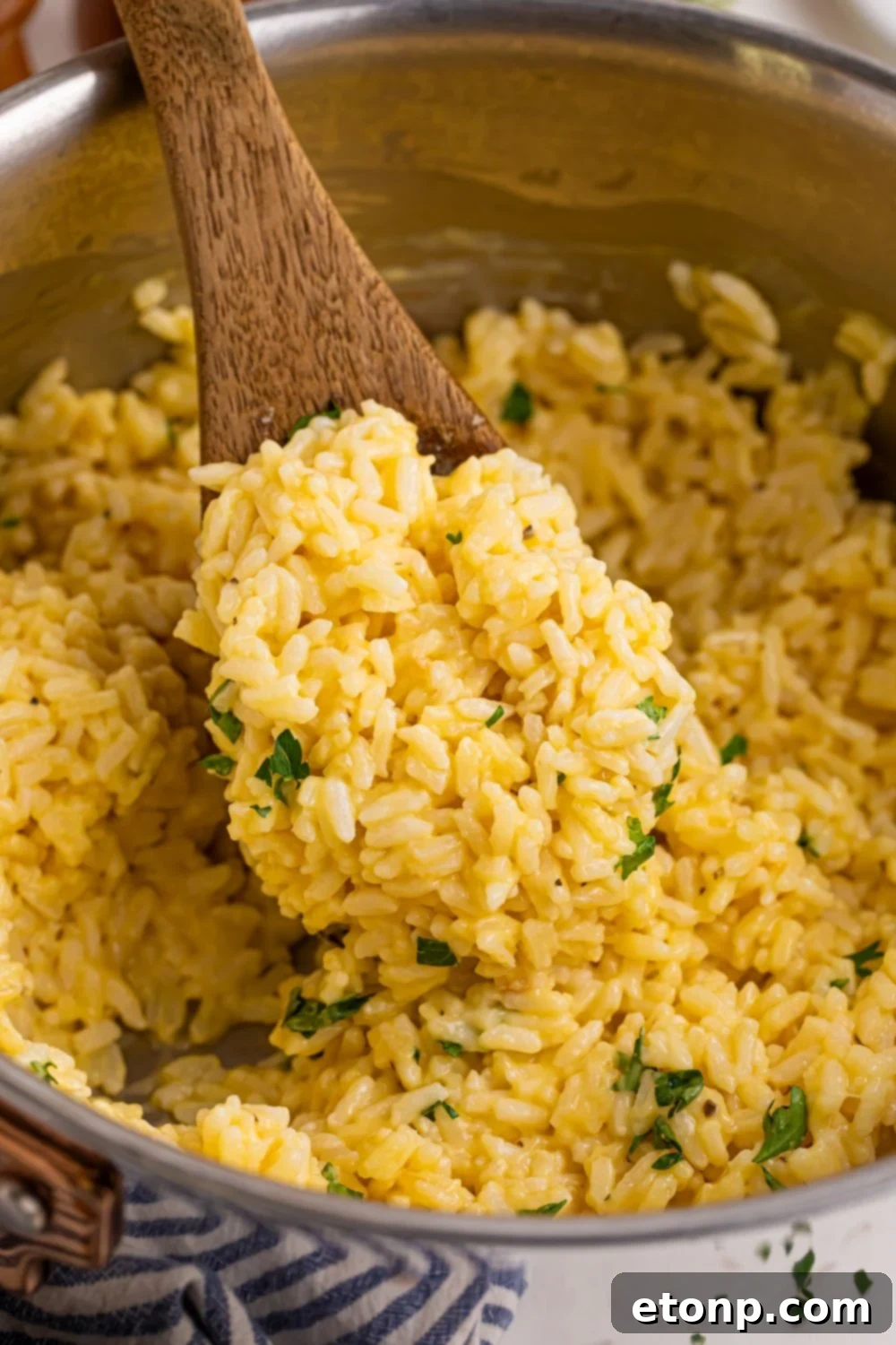 Souper Rice in a metal pan with a wooden spoon of rice in pan 