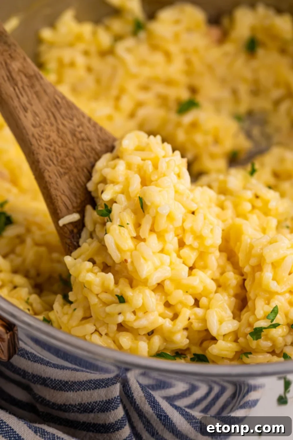Souper Rice in a metal pan with a wooden spoon with some rice on it in pan 