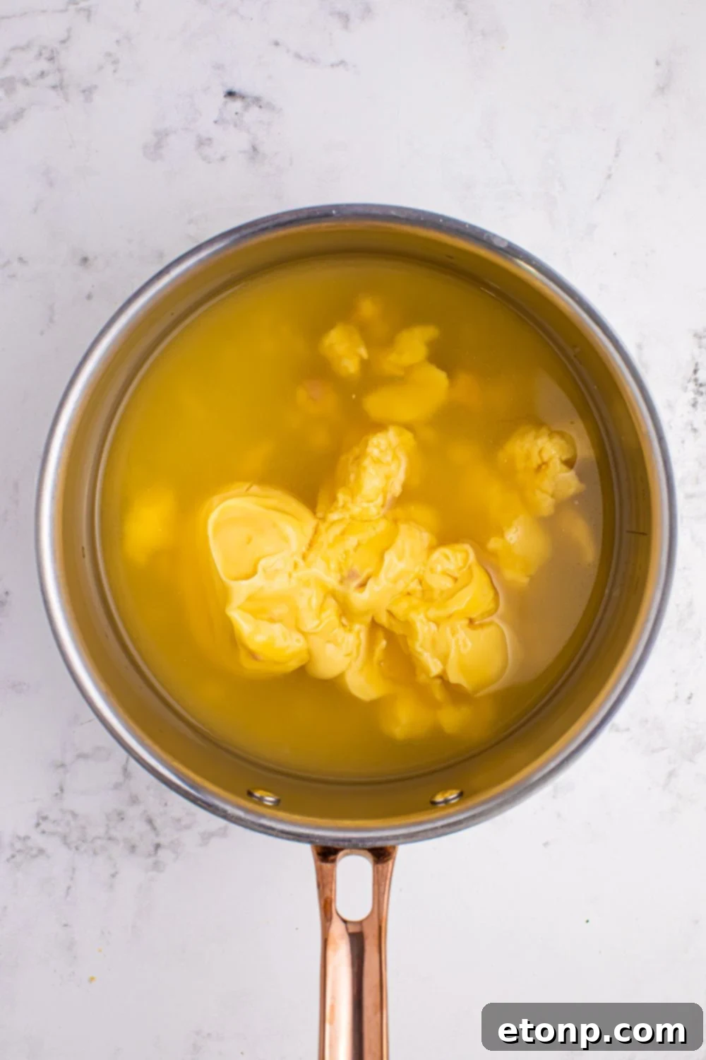 chicken stock in a saucepan with condensed soup poured in to make Souper Rice