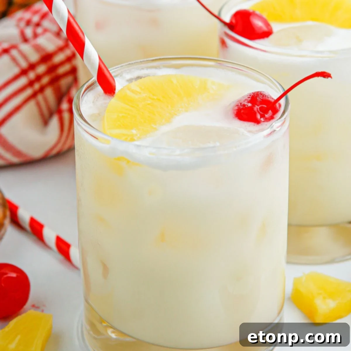 Pina Colada Punch served in glasses with festive red and white straws.