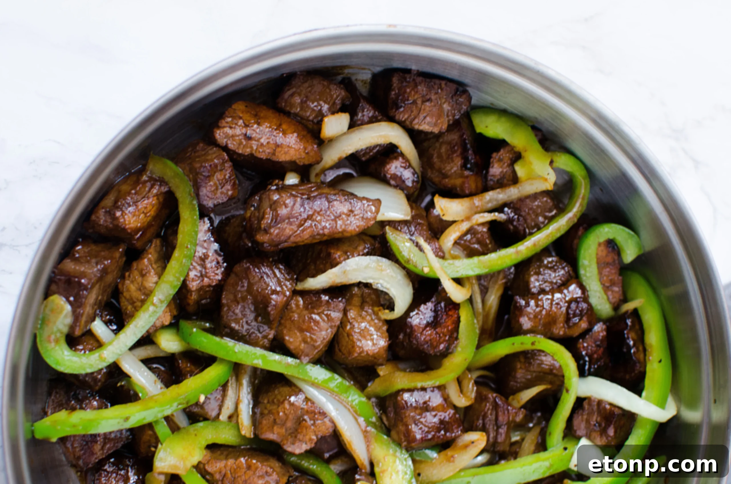 Marinated steak pieces glistening in the bowl, ready to be cooked.