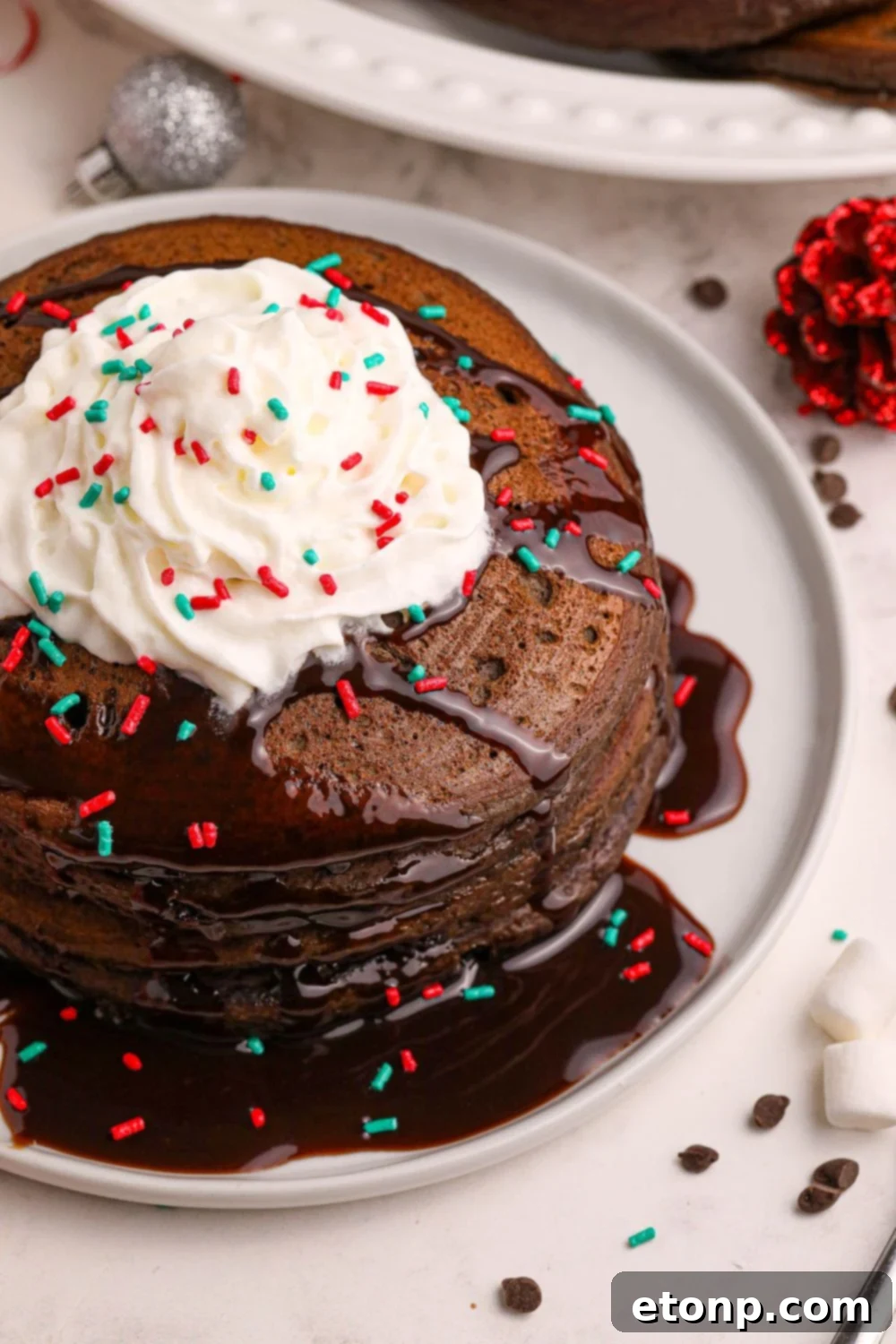 Hot Chocolate Pancakes arranged on plates with decorative sprinkles scattered around the table, creating a festive and inviting breakfast scene.