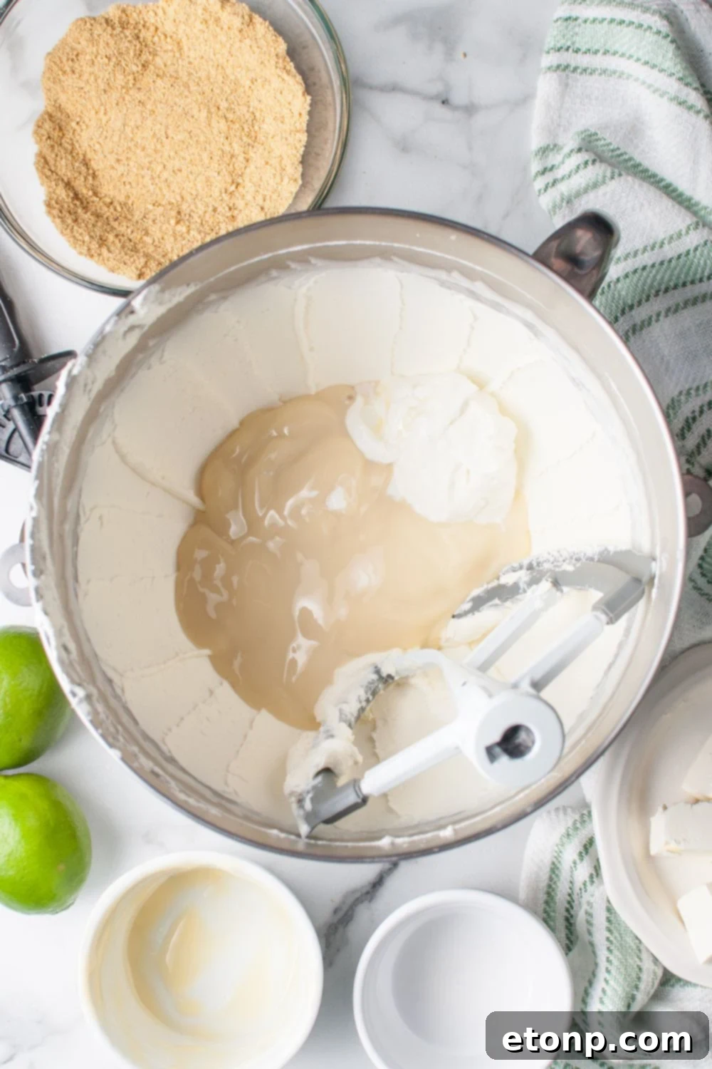 Crumbl Key Lime Pie Cookie filling in a mixer bowl with condensed milk poured in the center of bowl