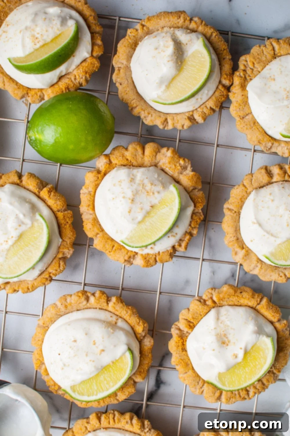 Crumbl Key Lime Pie Cookies on a cooling rack garnished with lime wedge and graham crackers