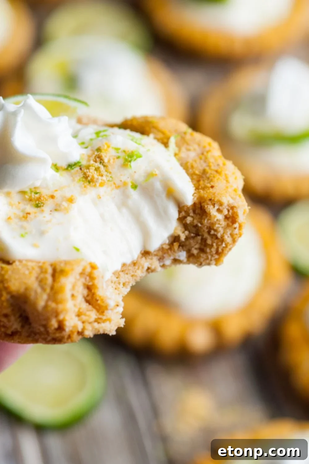 Crumbl Key Lime Pie Cookie in hand with a bite taken out of it