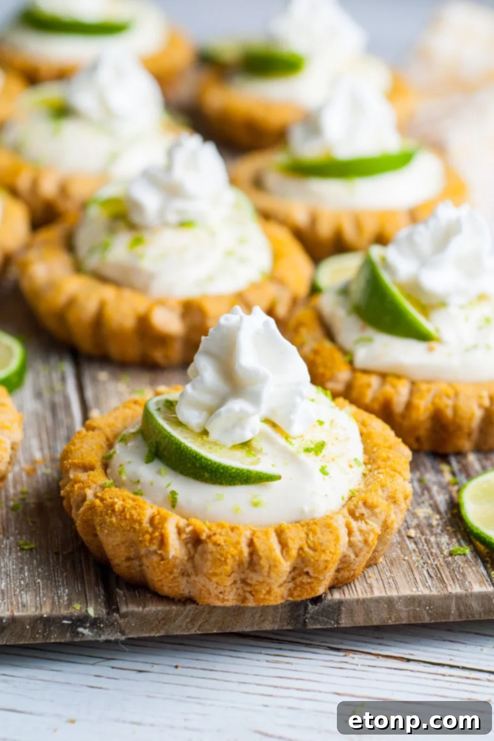 Crumbl Key Lime Pie Cookies lined out on a cutting board on table