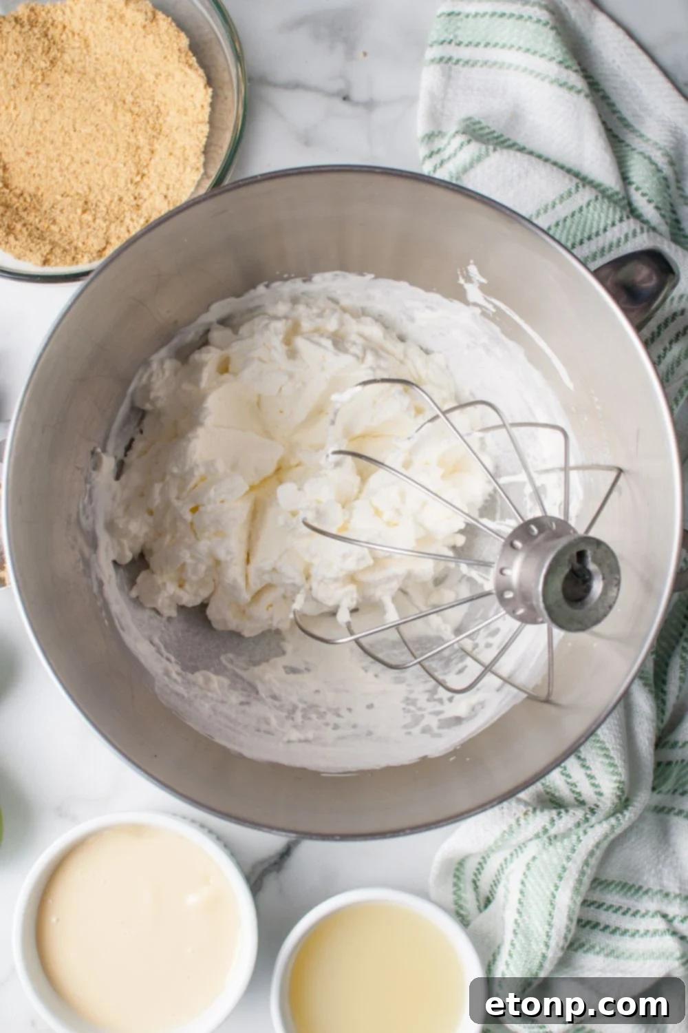 whipped cream cheese in a mixer bowl for the Crumbl Key Lime Pie Cookies