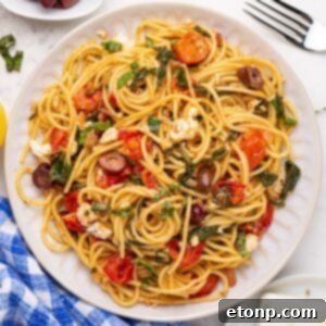 Greek Spaghetti dish on a plate with a fork