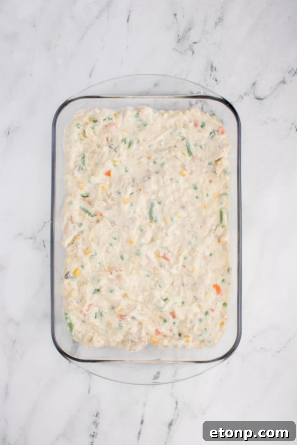 wet Chicken Stuffing Casserole mixture spread evenly in a glass casserole dish