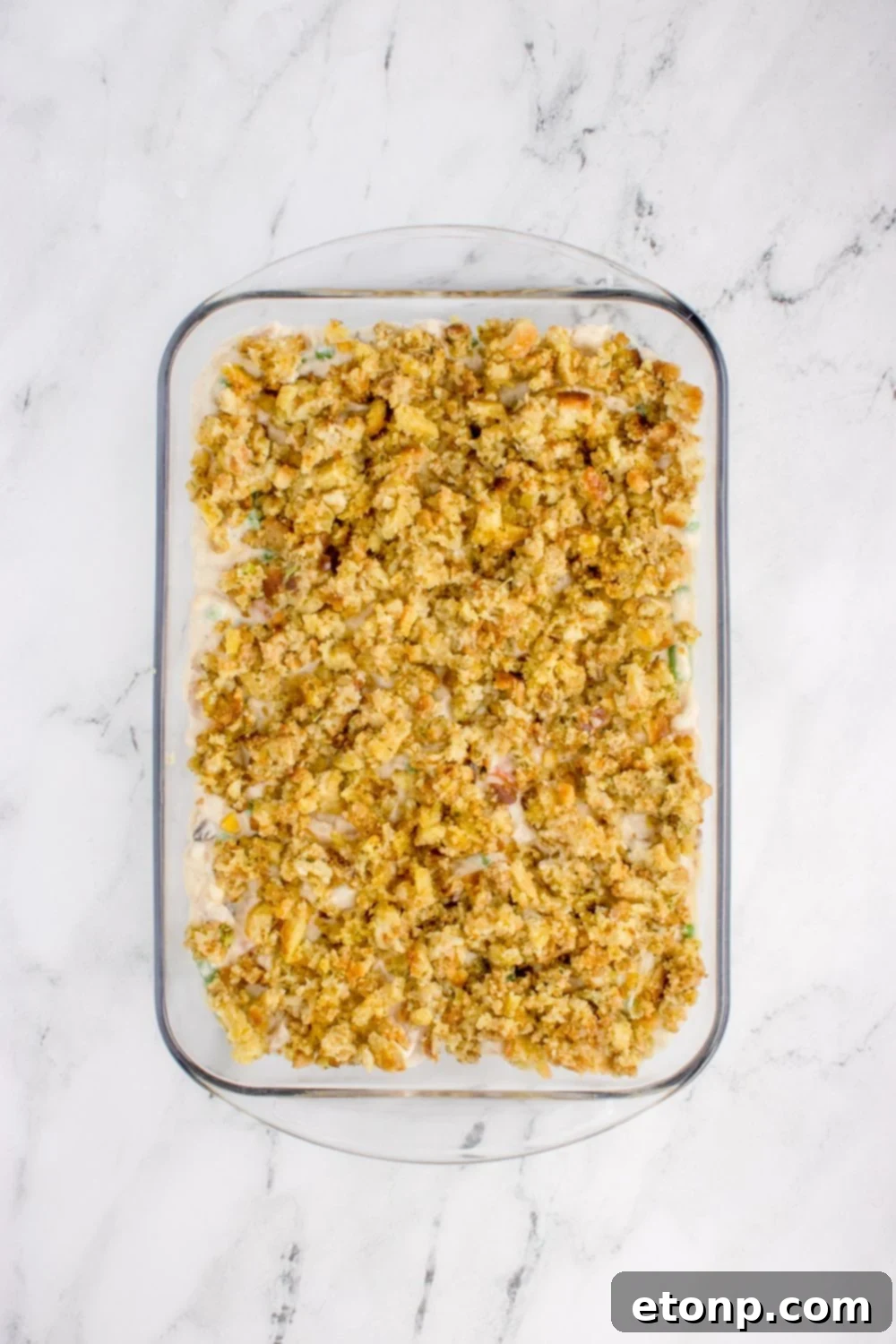 Chicken Stuffing Casserole in a pan unbaked on a marble counter 