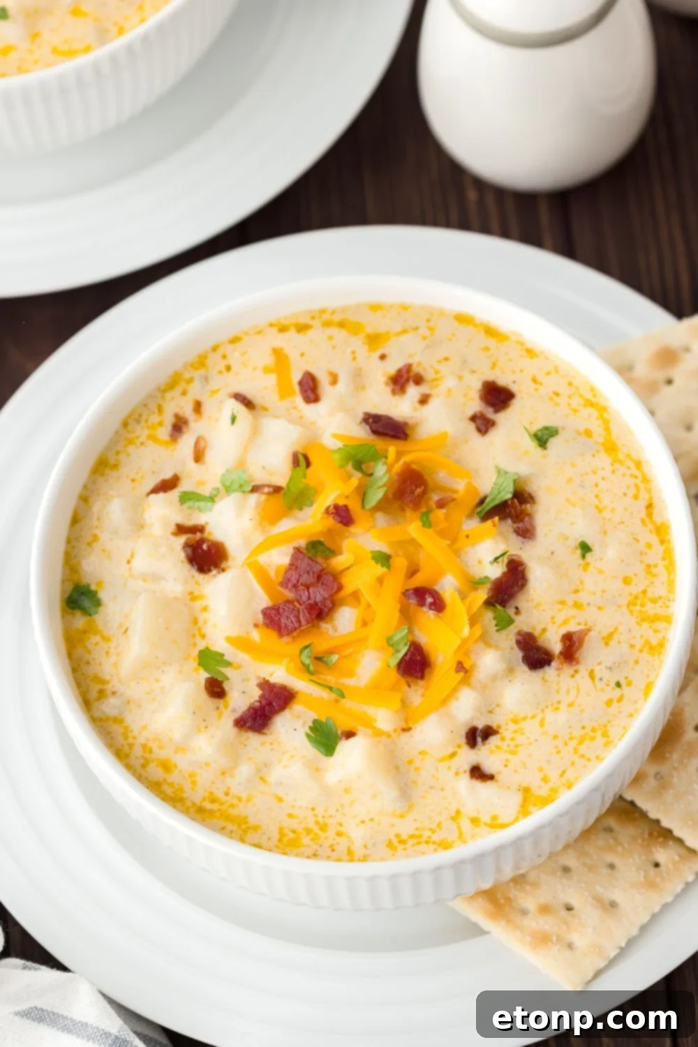 Hash Brown Potato Soup in bowls on table with salt and pepper on the side 