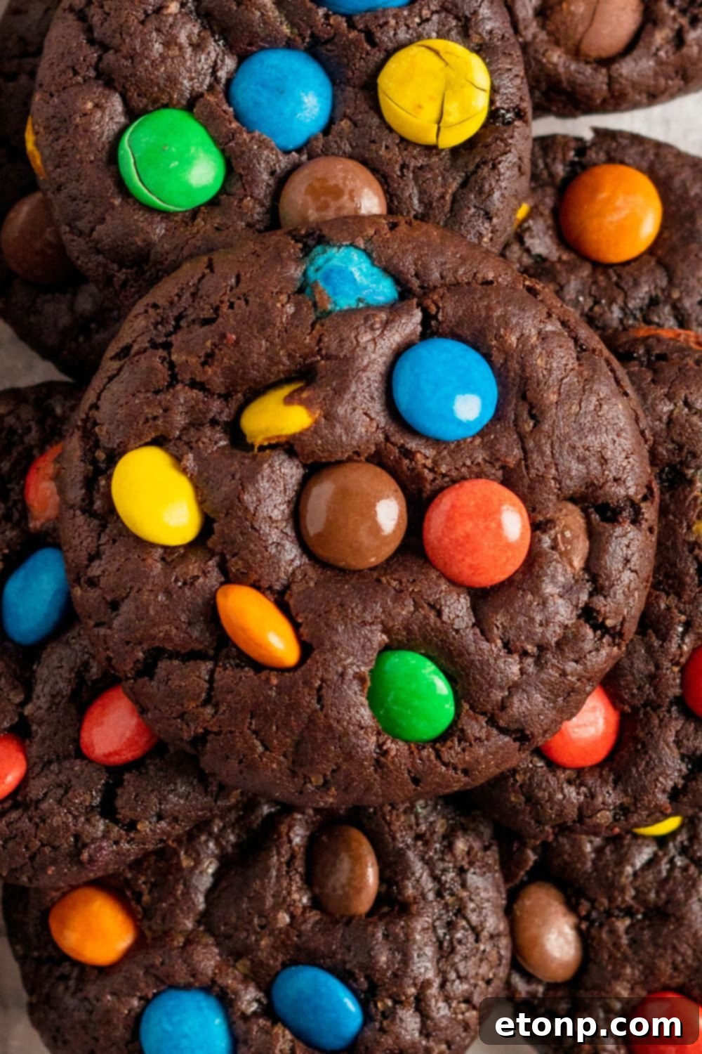 Chocolate M&M Cookies stacked on top of each other, with a close up to see all the M&Ms in the cookie 