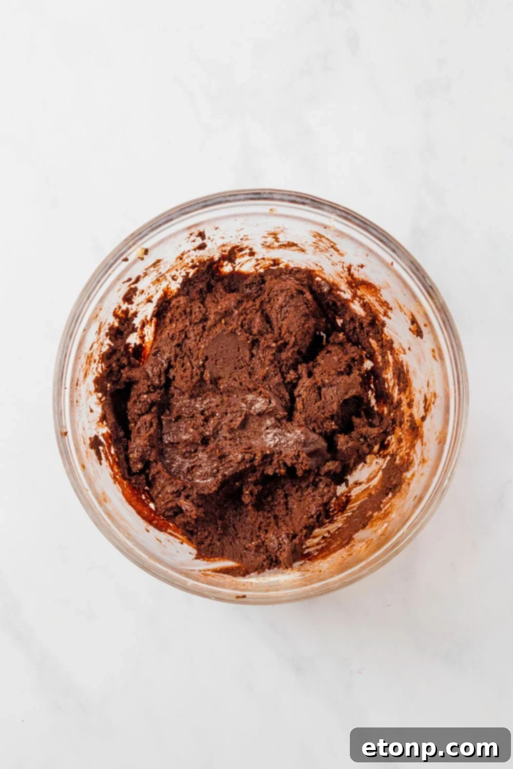 Chocolate M&M Cookie dough in a  glass bowl on table 