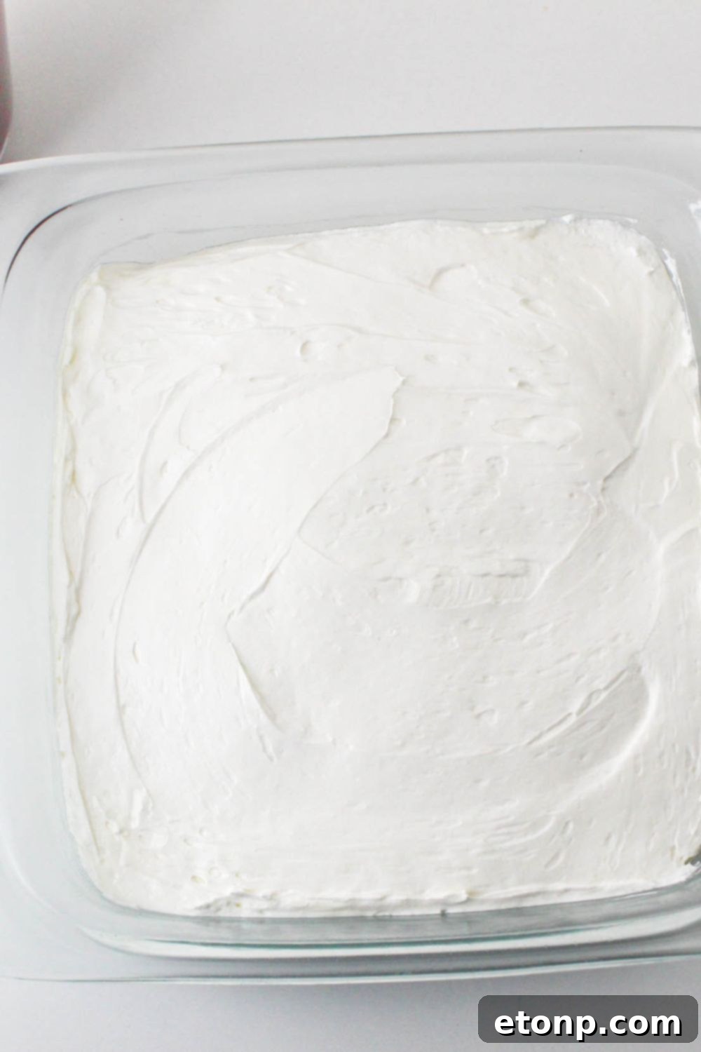 No Bake Strawberry Delight in pan with a whippd cream layer spread over the top