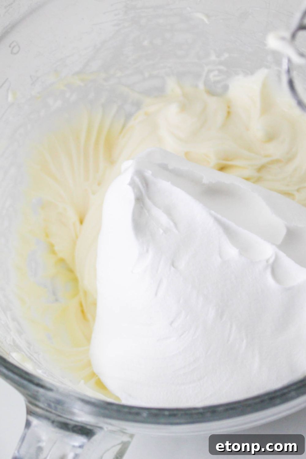 No Bake Strawberry Delight mixture in a bowl with whipped cream on top 