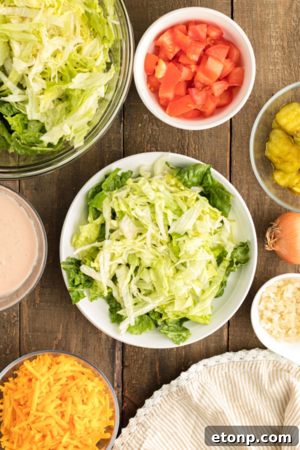 A bed of crisp green lettuce mix is arranged on a plate, forming the fresh base for assembling the Big Mac Salad.