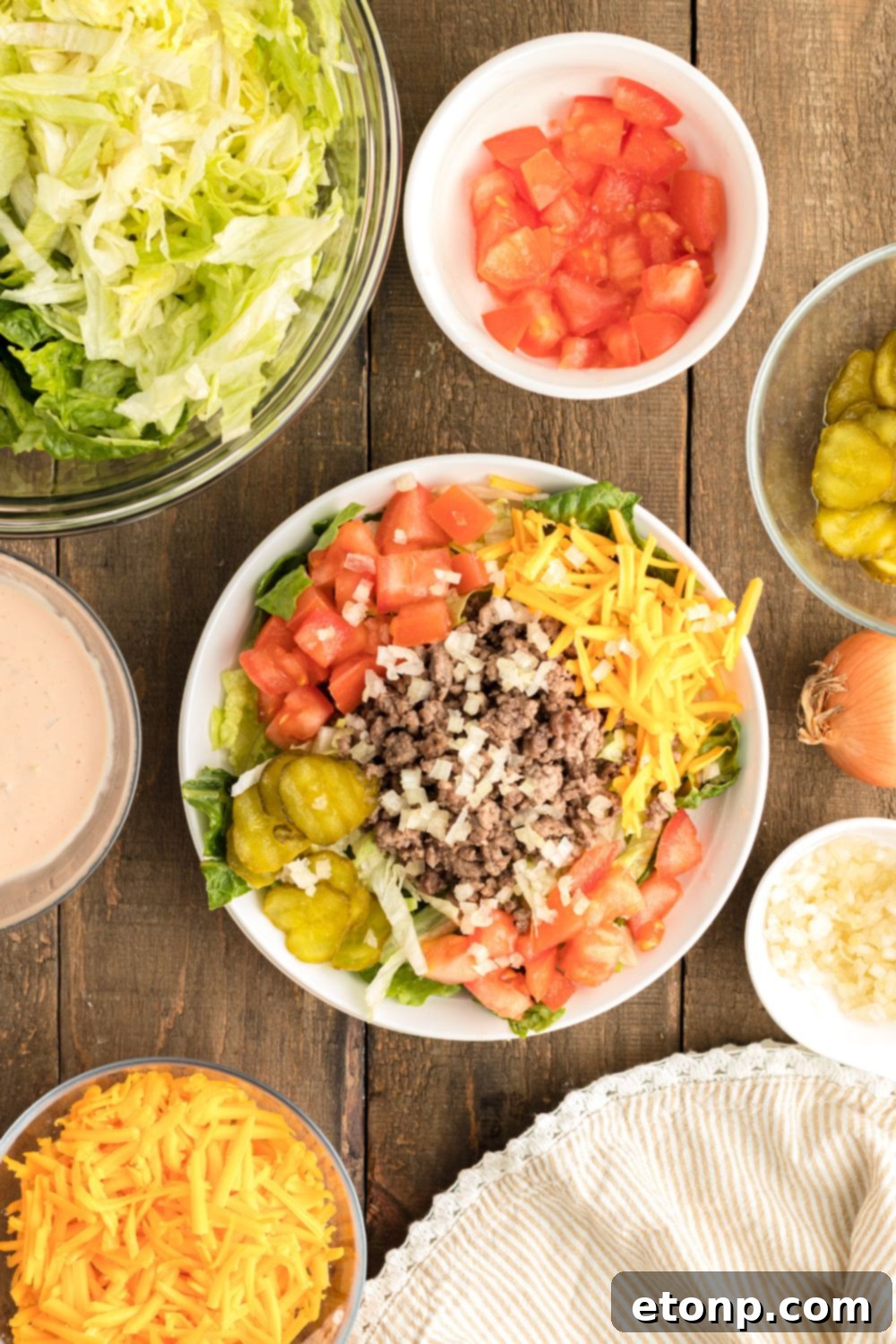 A beautifully assembled Big Mac Salad on a plate, showcasing all the vibrant ingredients layered together and ready to be drizzled with dressing.
