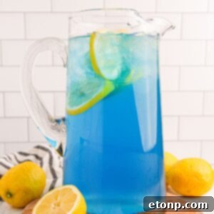 Delicious Blue Raspberry Lemonade in a pitcher, garnished with fresh lemon slices, ready to serve.