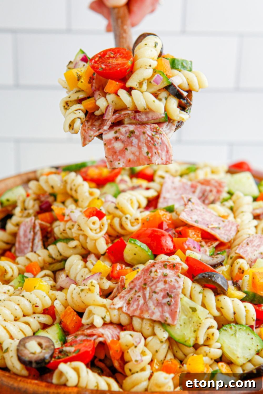 Vibrant Summer Pasta Salad 12 spoon with Summer Pasta Salad sitting over a bowl of pasta salad