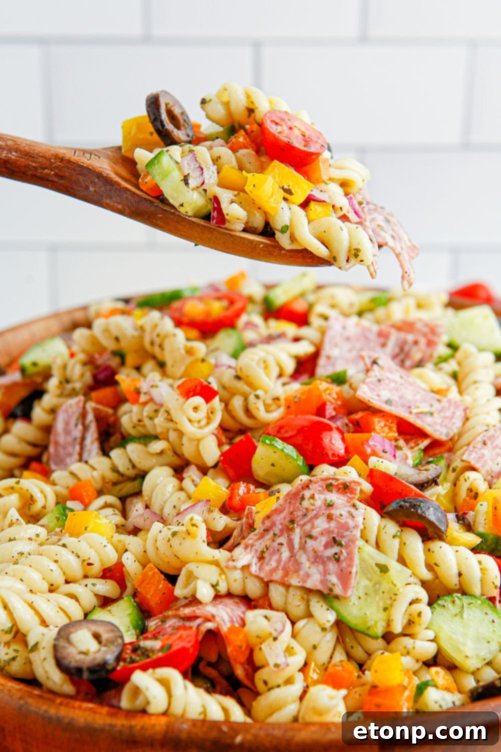 Vibrant Summer Pasta Salad 14 Summer Pasta Salad in a wooden bowl with a spoon full of pasta salad