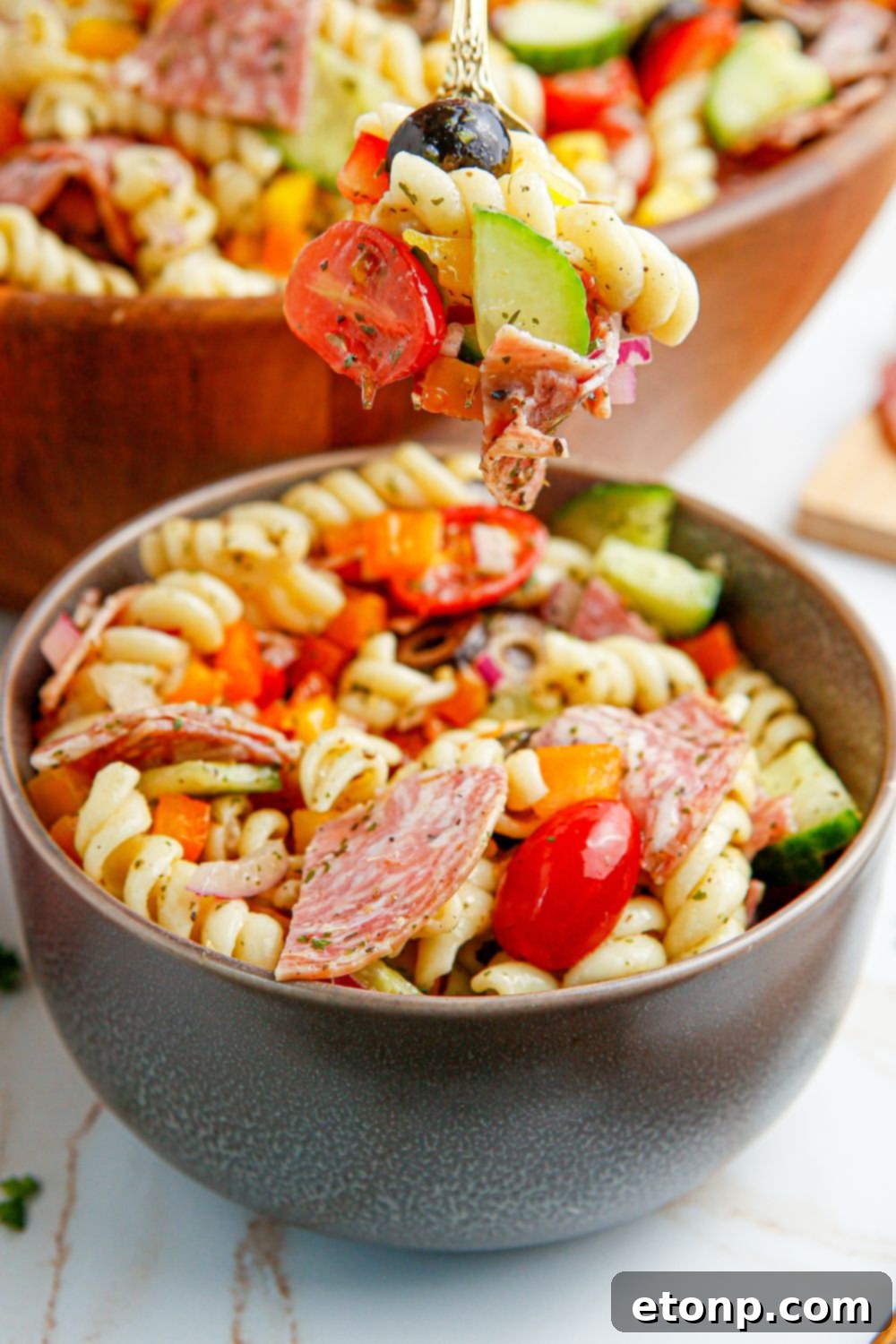 Vibrant Summer Pasta Salad 16 Summer Pasta Salad in a bowl with a fork with some of the salad on it
