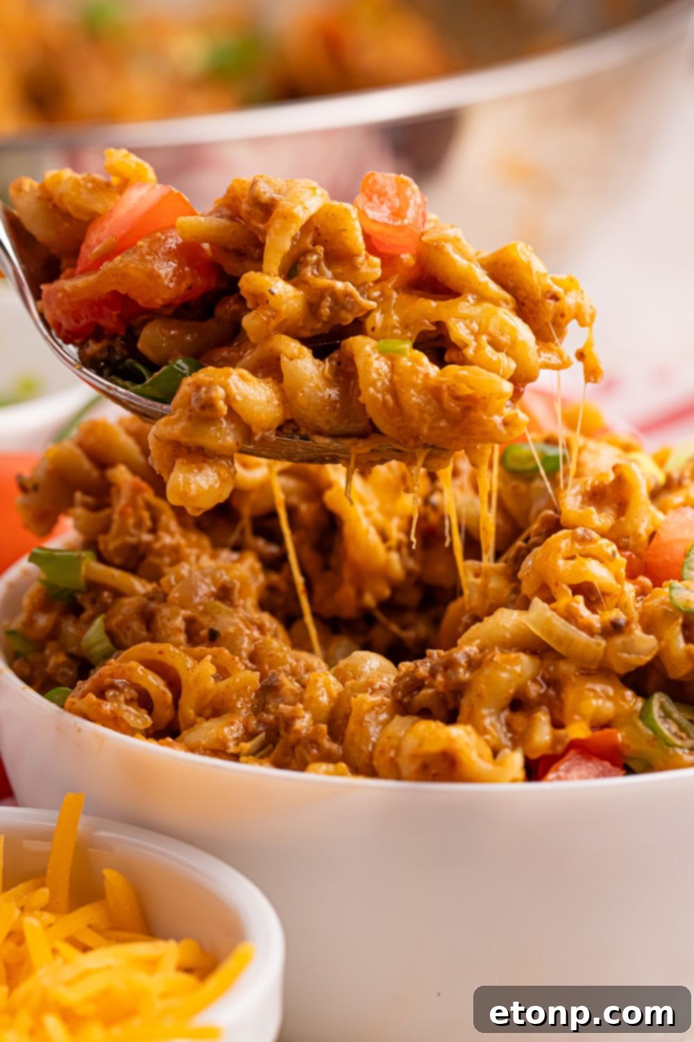 Taco Macaroni and Cheese in a bowl with a fork of pasta in it 