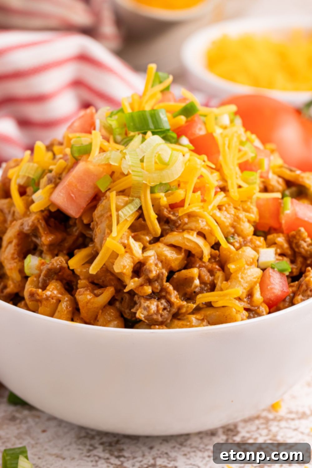 Taco Macaroni and Cheese in a bow with lettuce and tomatoes on it 