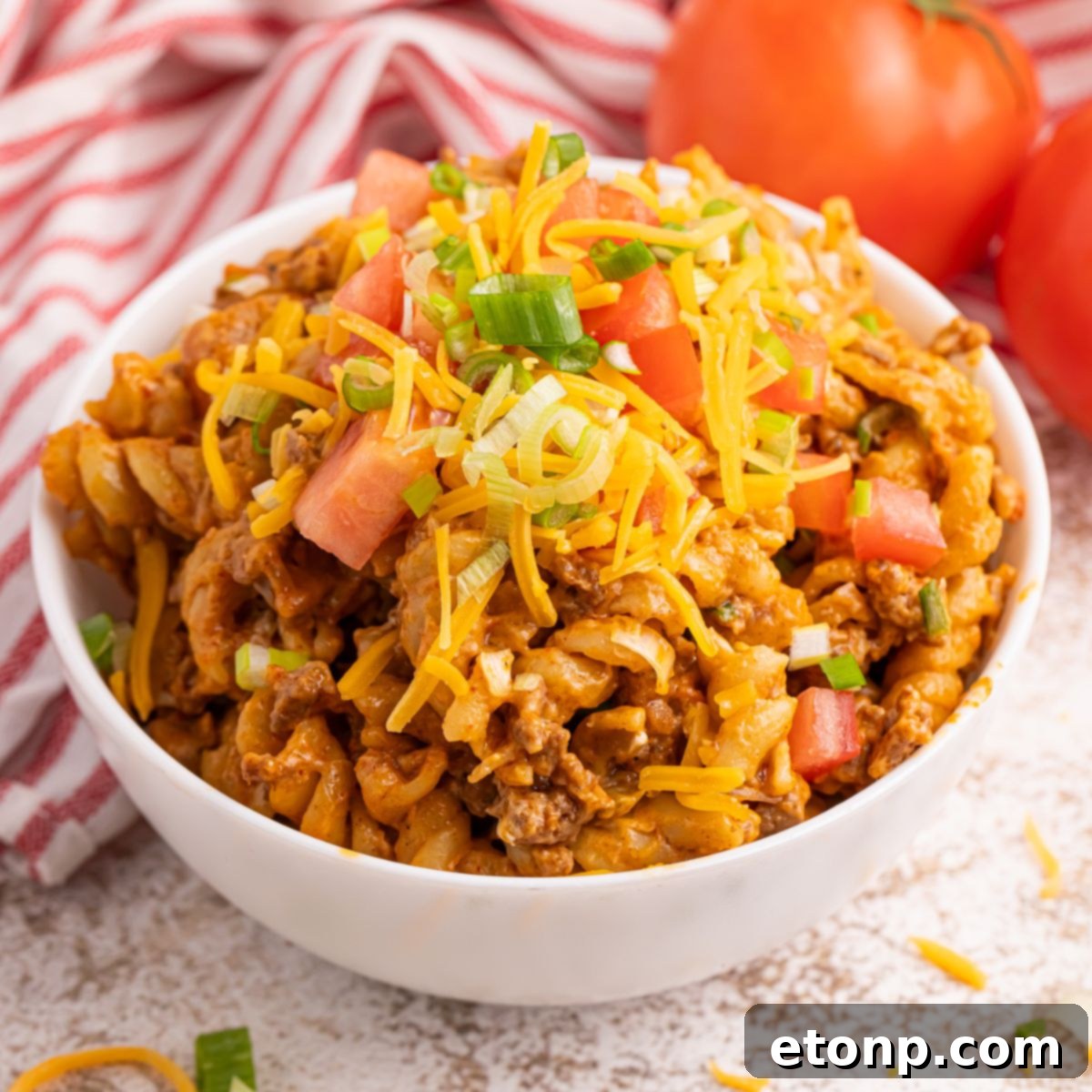 Taco Macaroni and Cheese in a bowl with shredded cheese on top 