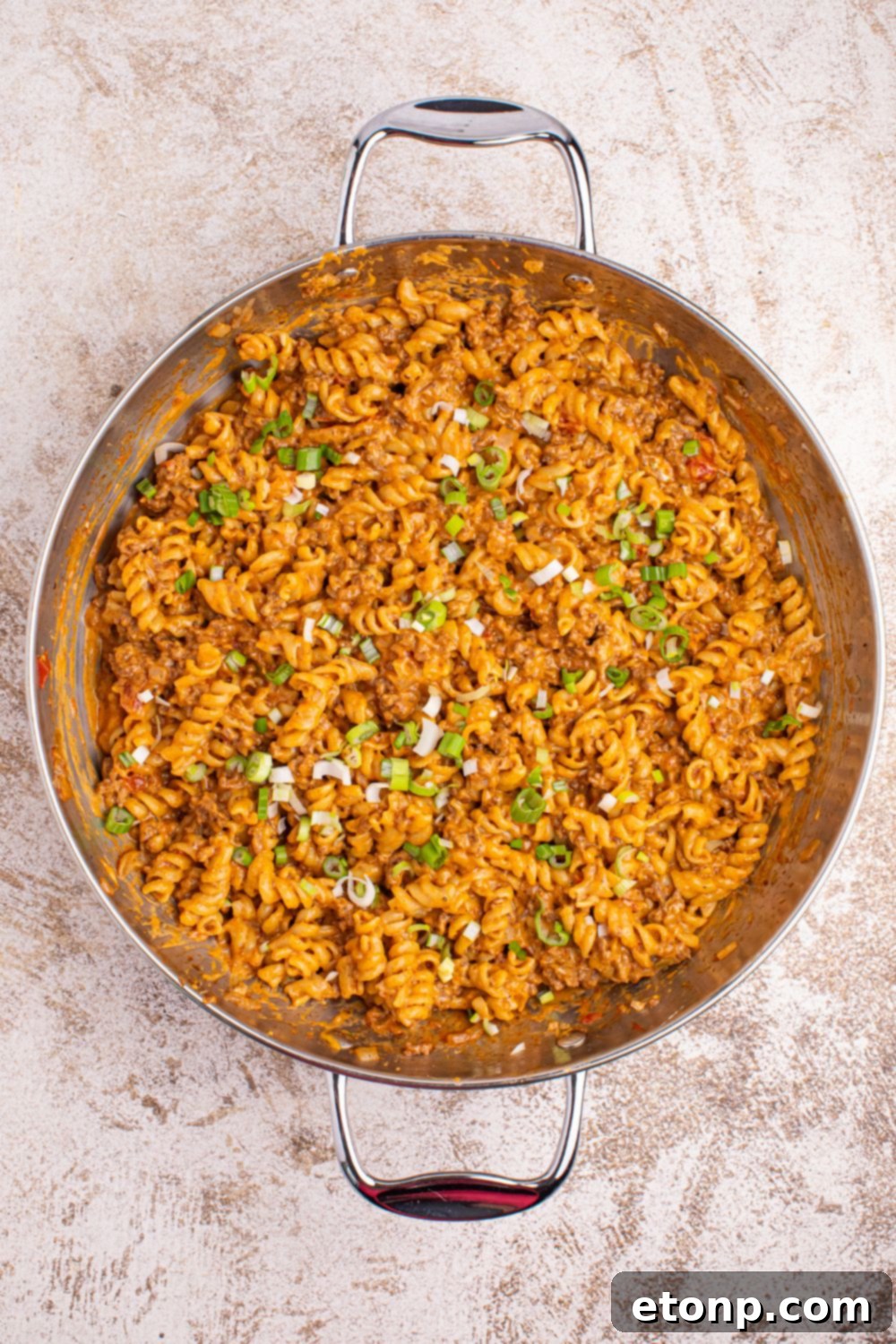 Taco Macaroni and Cheese in a skillet with garnish on top of the pan