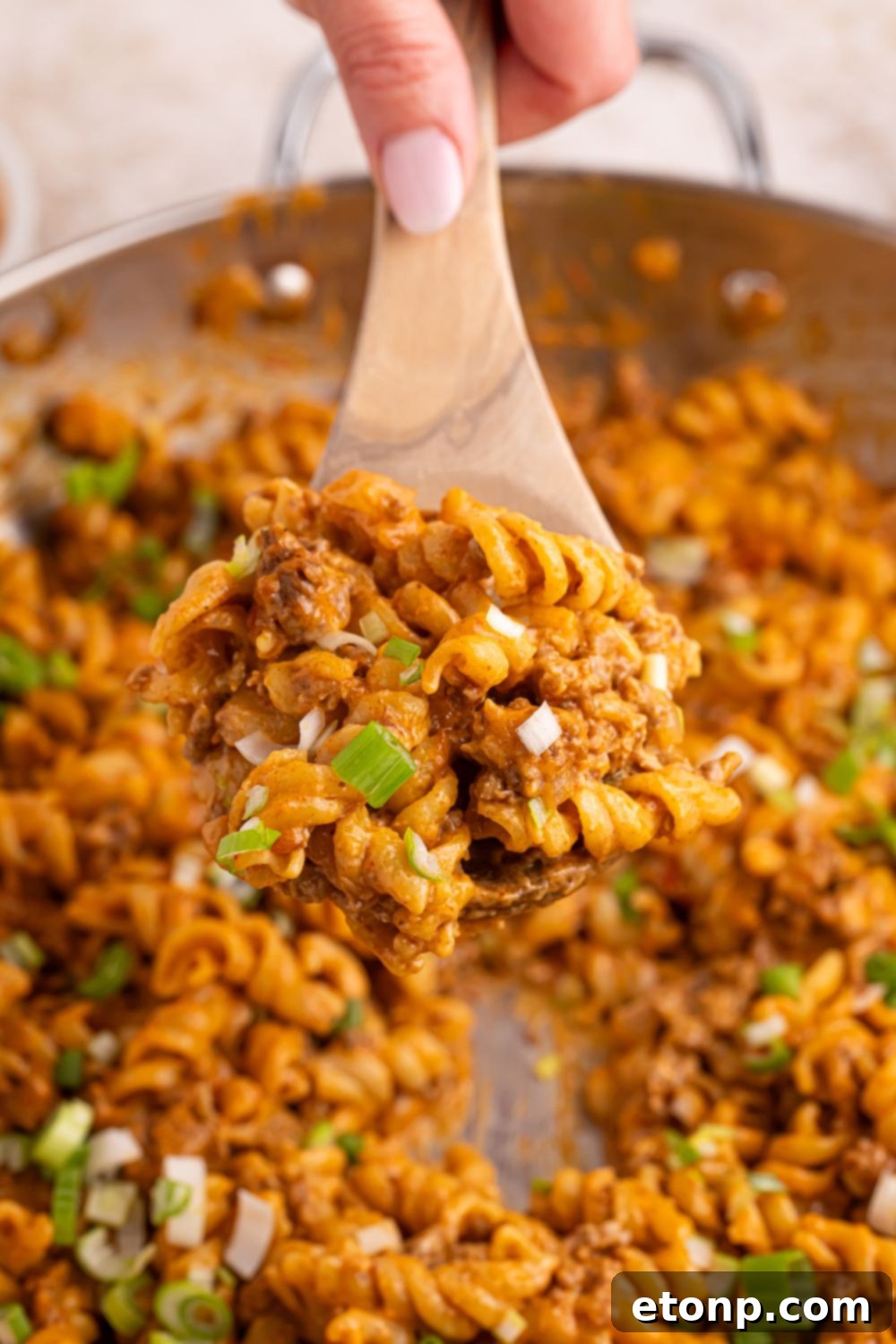 Taco Macaroni and Cheese in a pan with a wooden spoon in pan 