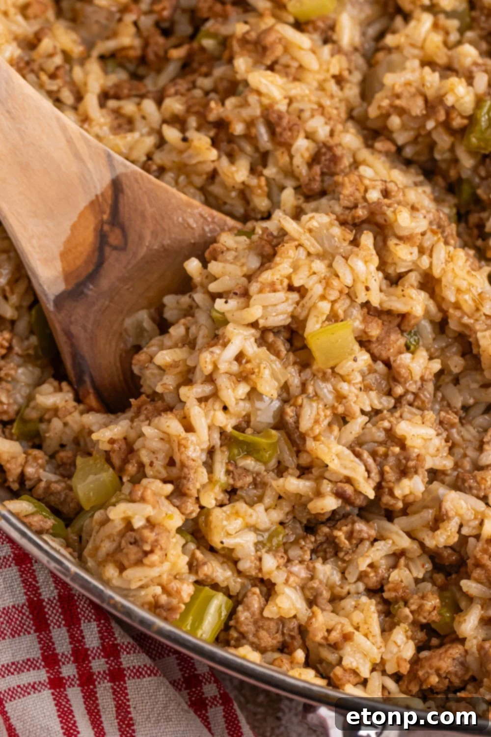 Cajun Dirty Rice 12 close up of Dirty Rice in a pan with a wooden spoon in it