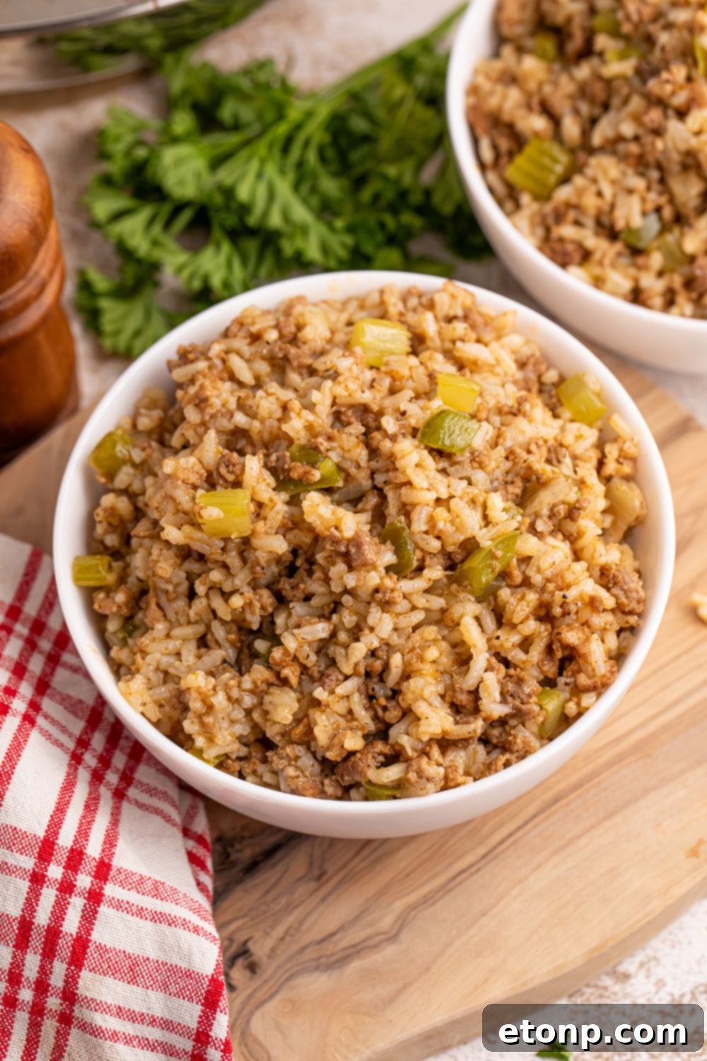 Cajun Dirty Rice 13 Dirty Rice in a bowl on cutting board with ingredients around it on table