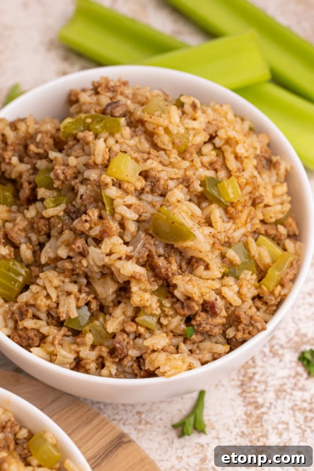 Cajun Dirty Rice 17 Dirty Rice in serving bowls with celery stalks behind it on table