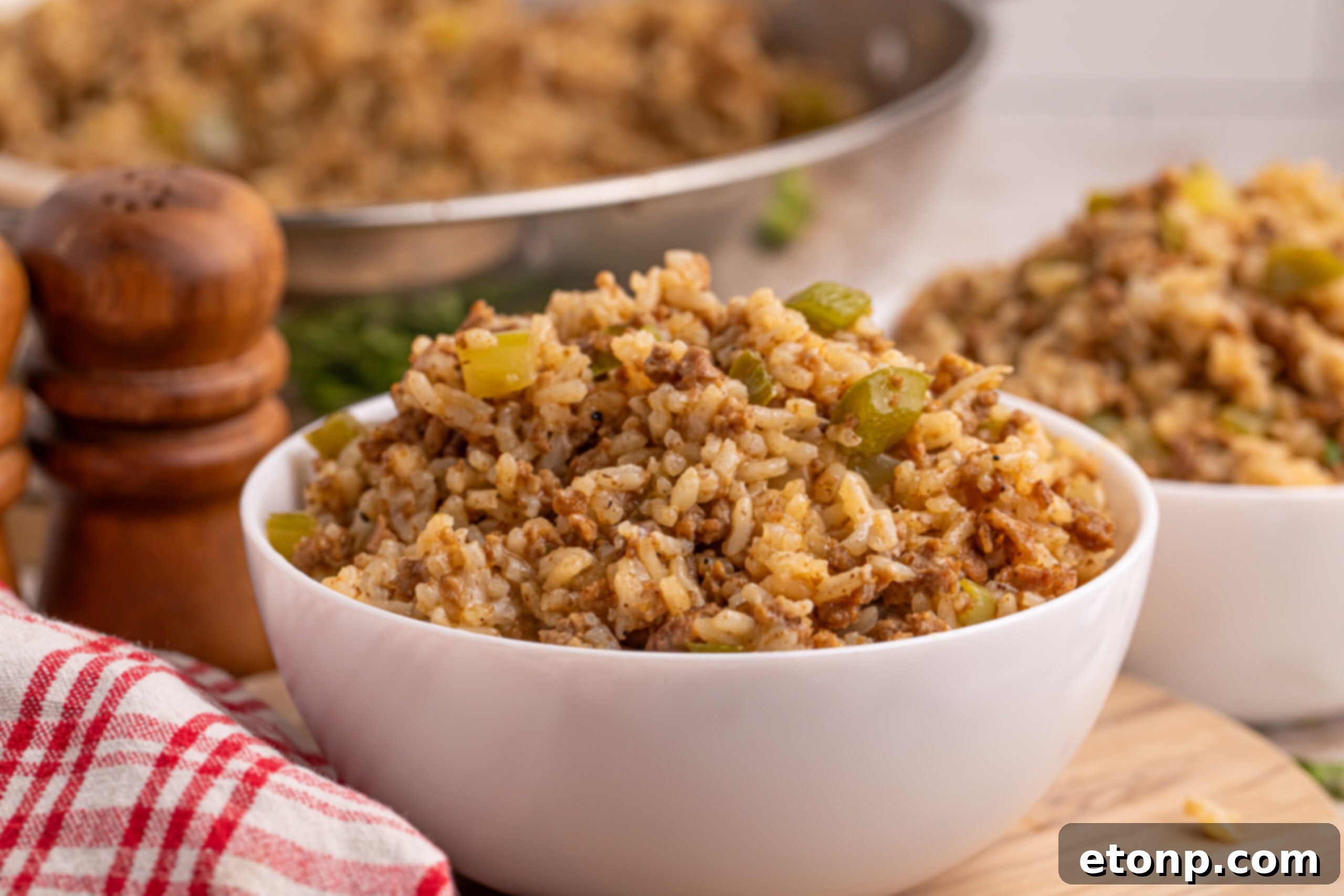 Cajun Dirty Rice 4 Dirty Rice in a white bowl sitting on wooden brown table
