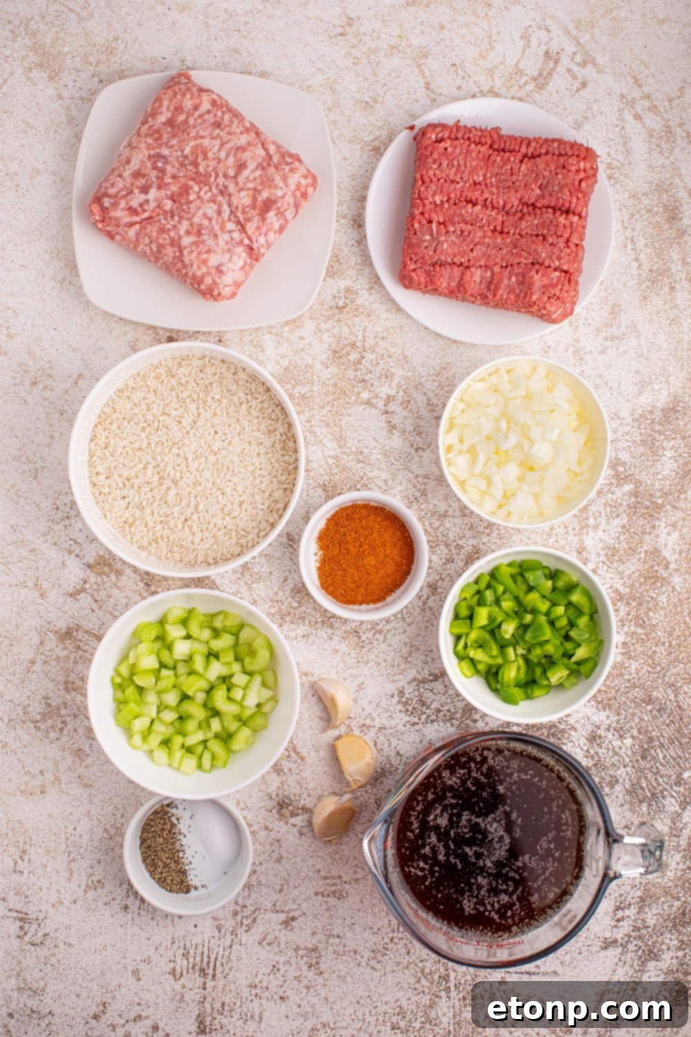 Cajun Dirty Rice 7 ingredients for Dirty Rice sitting on a marble table in single serve bowls