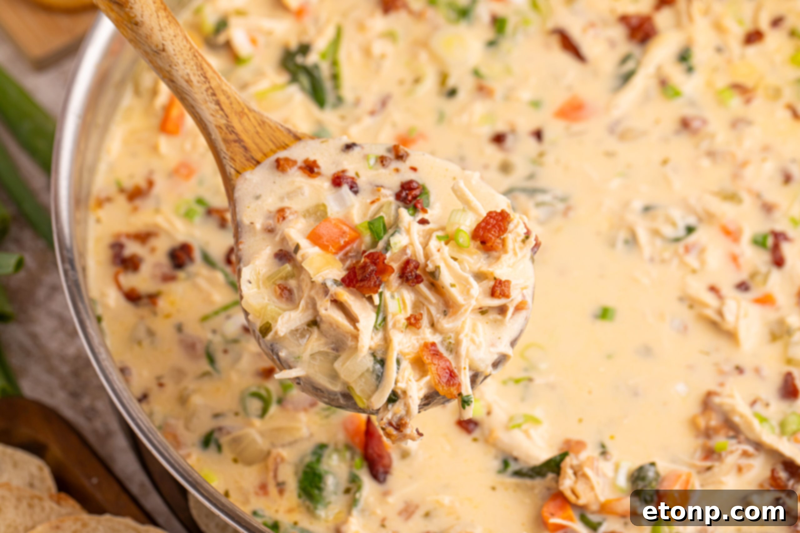 Creamy Ranch Chicken Soup 13 Crack Chicken Soup in a pan with a wooden spoon full of soup being held above the pan