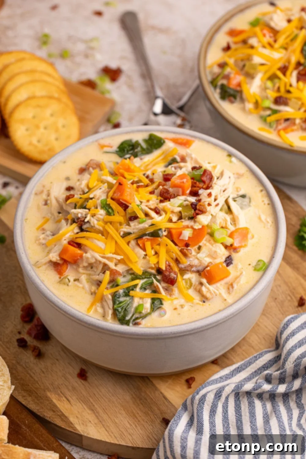 Creamy Ranch Chicken Soup 16 soup in bowls on table with a spoon in bowl and crackers behind it on table
