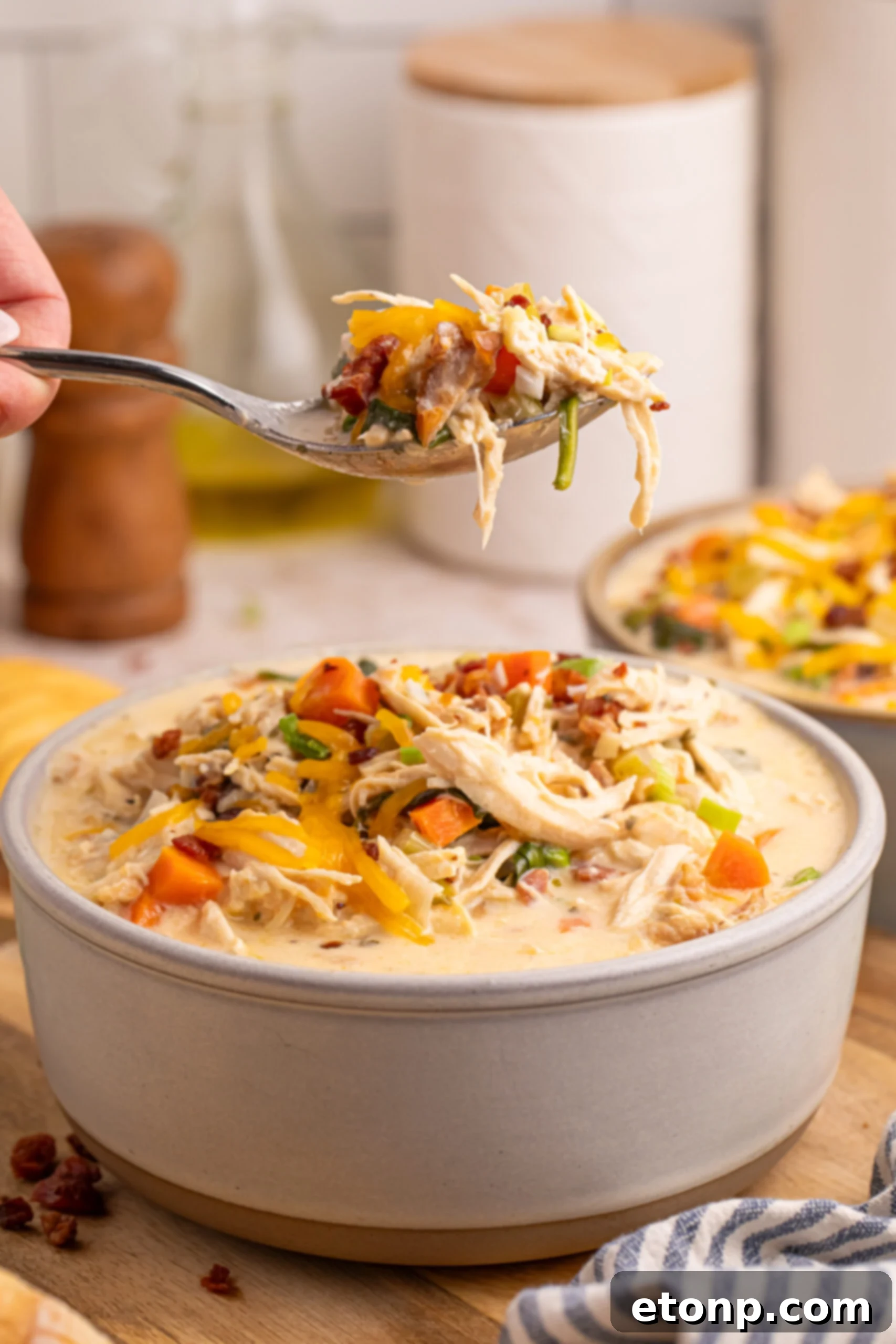 Creamy Ranch Chicken Soup 17 Crack Chicken Soup in a bowl with a spoon lifting up a bite