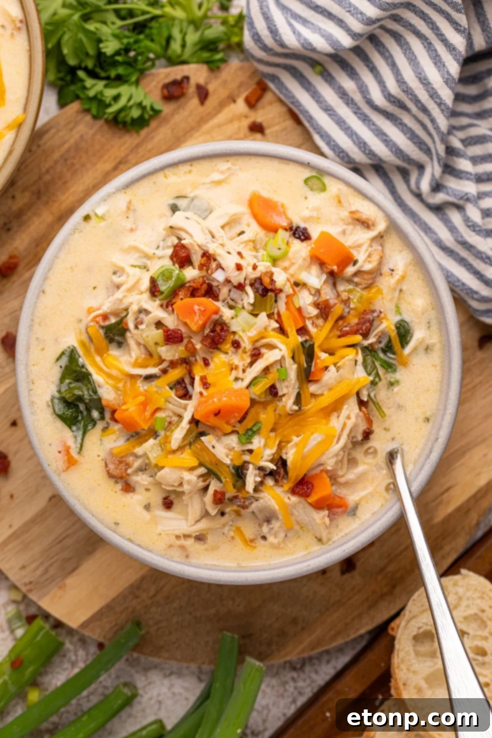 Creamy Ranch Chicken Soup 19 ovrhead look of Crack Chicken Soup in a bowl with a spoon on the side. The bowl is sitting on table