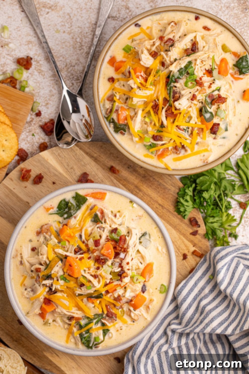 Creamy Ranch Chicken Soup 20 Crack Chicken Soup sitting in bowls on table with garnishments around the bowls on table