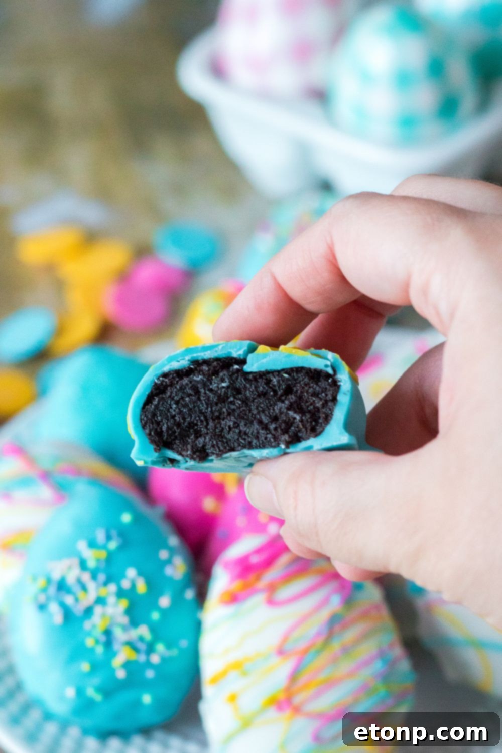 Easter Egg Oreo Truffle in hand with it bit in half 